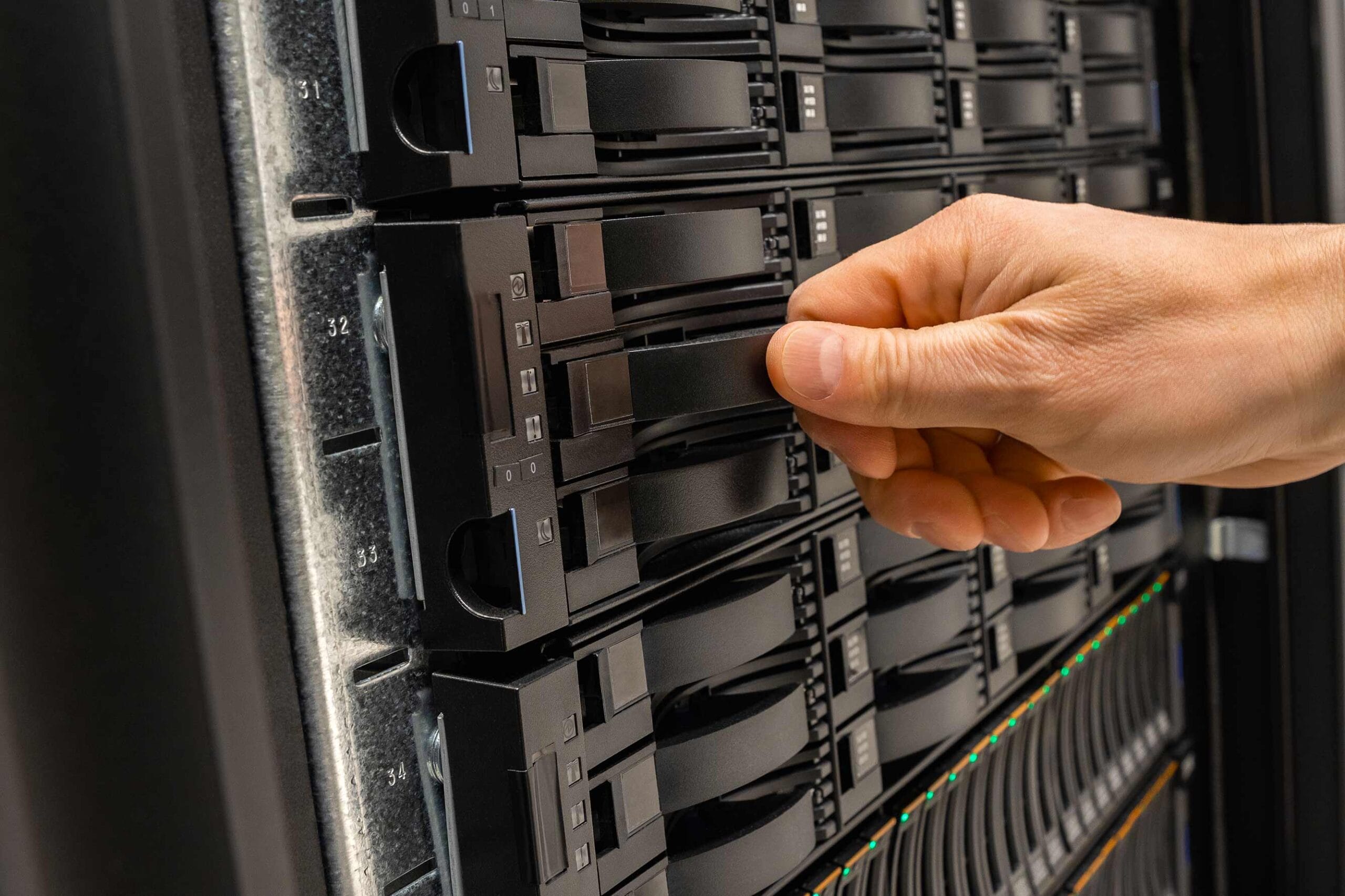 Foto di un tecnico informatico che ha appena rimpiazzato una memoria all'interno di un server da lui costruito